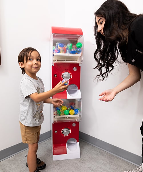 A child and one of our Cadence Kids Dental assistants in a toy machine